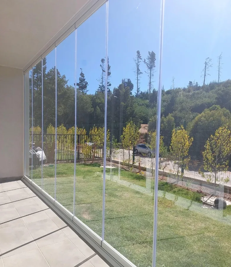 Quincho en Chicureo cerrado con vidrio plegable frente a un jardín