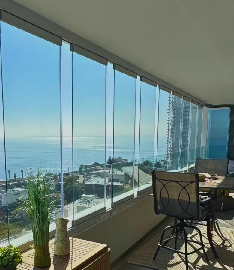 Terraza en Concón con cierre plegable de vidrio y vista al mar